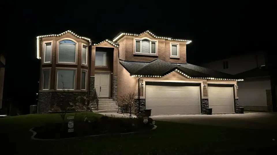 Edmonton home with warm white permanent outdoor lighting at night