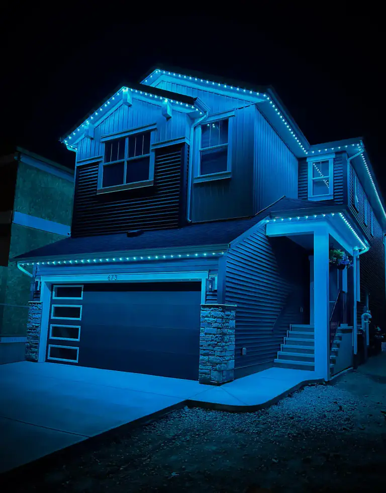 Teal blue permanent LED lighting on modern Edmonton home at night