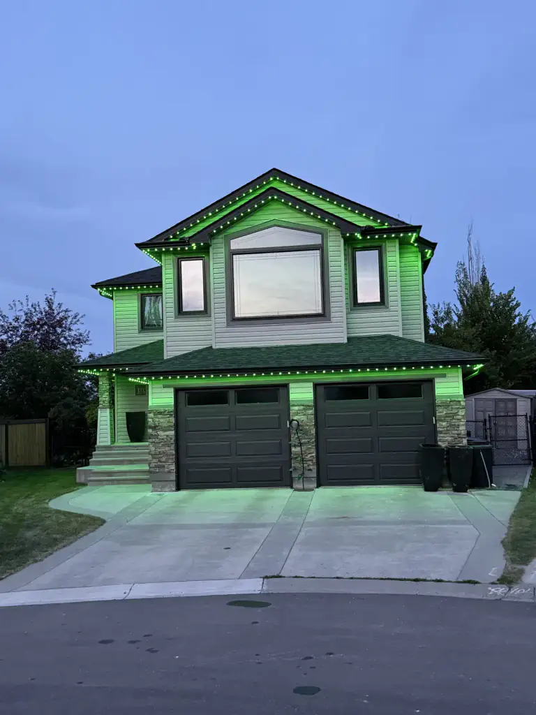 Green permanent LED lighting on Edmonton home at dusk