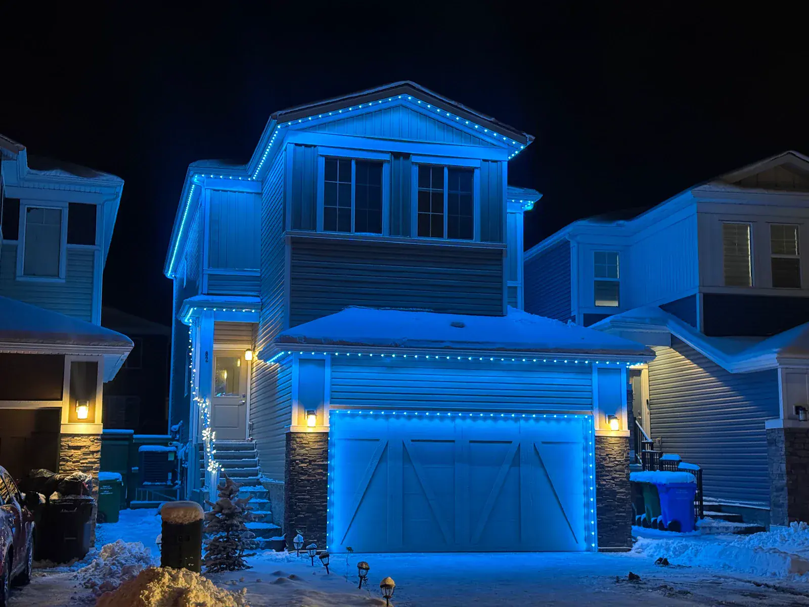Blue permanent outdoor lights on a Kelowna home at night
