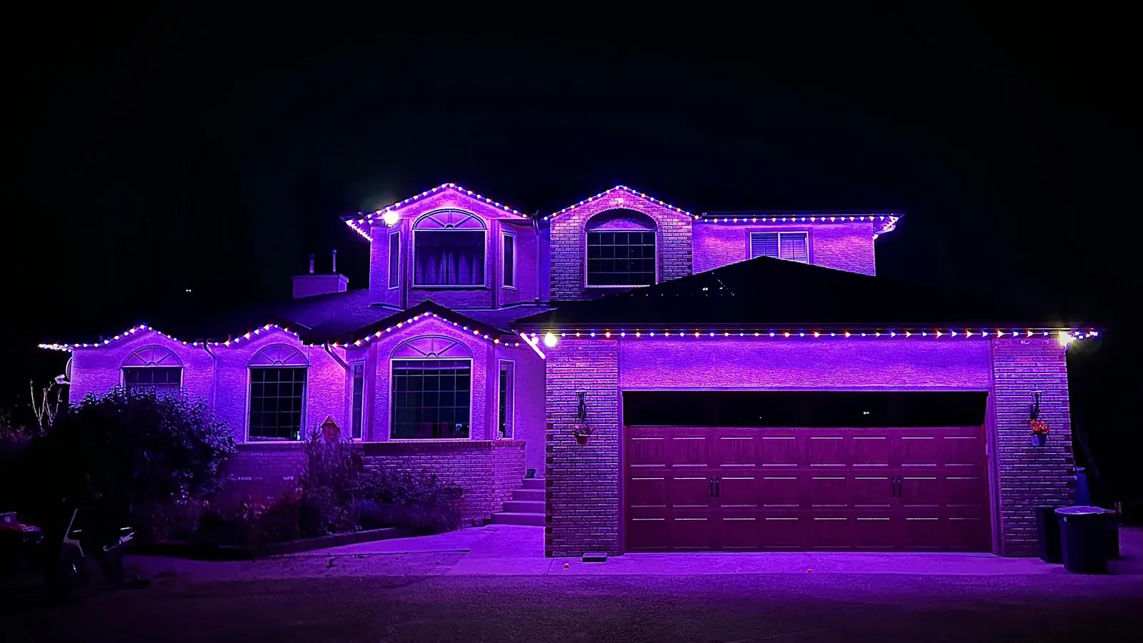 Purple permanent outdoor lights on a Kelowna home at night