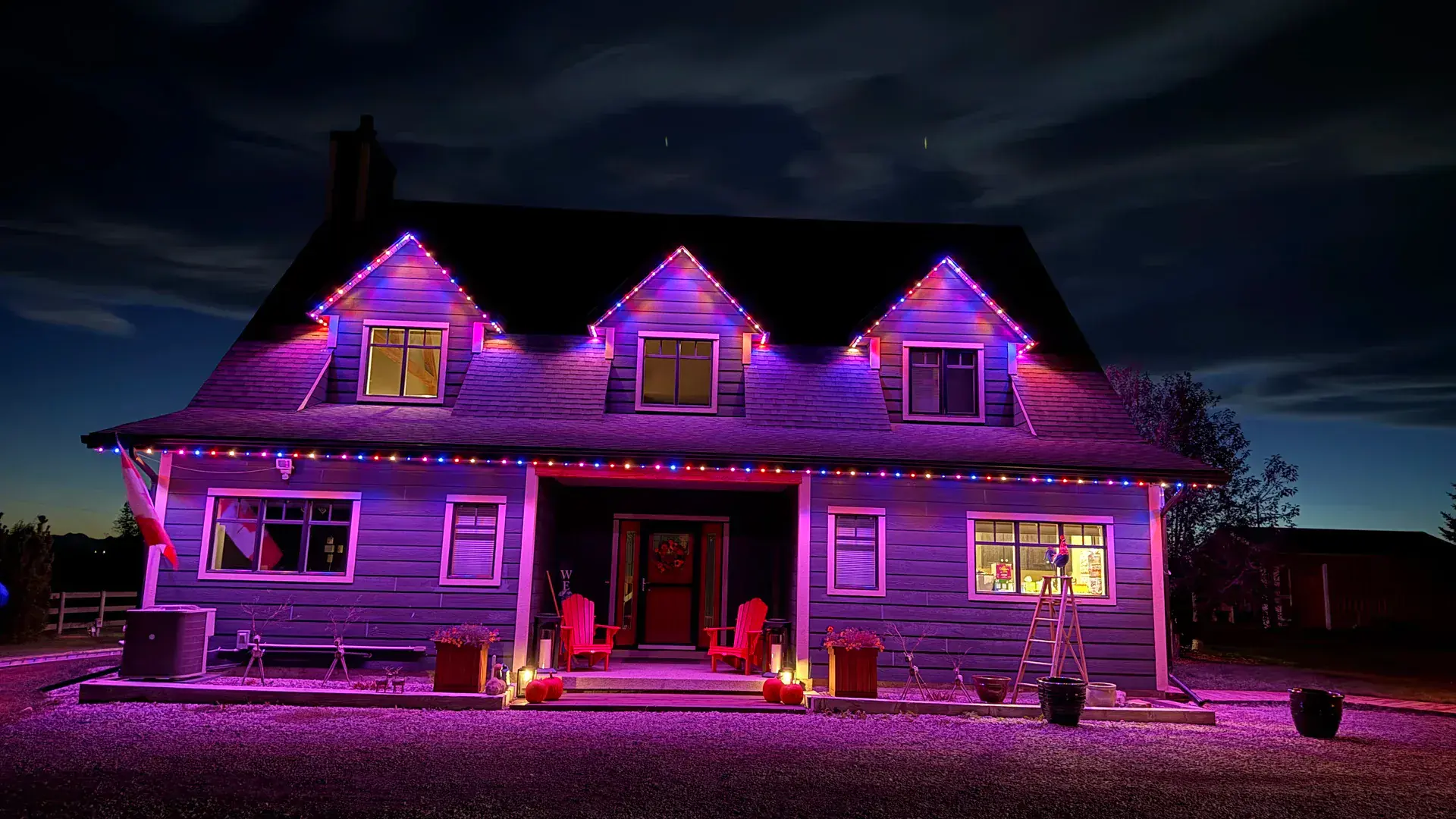 Warm white permanent Christmas lights illuminating an Edmonton home at dusk