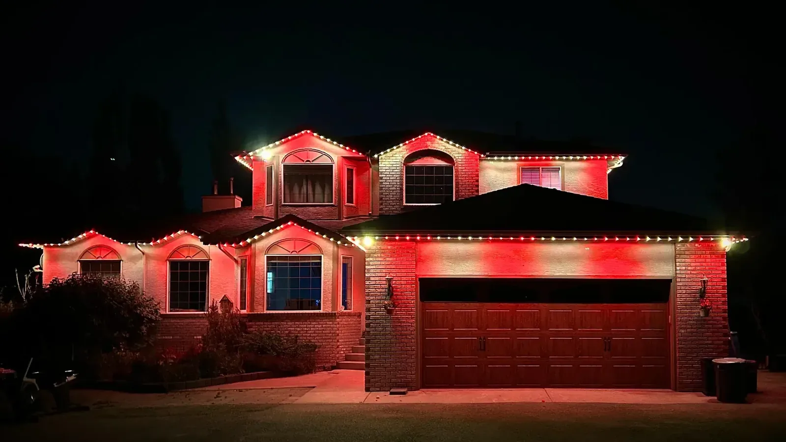 Edmonton home illuminated with red and white permanent soffit lighting for Canada Day