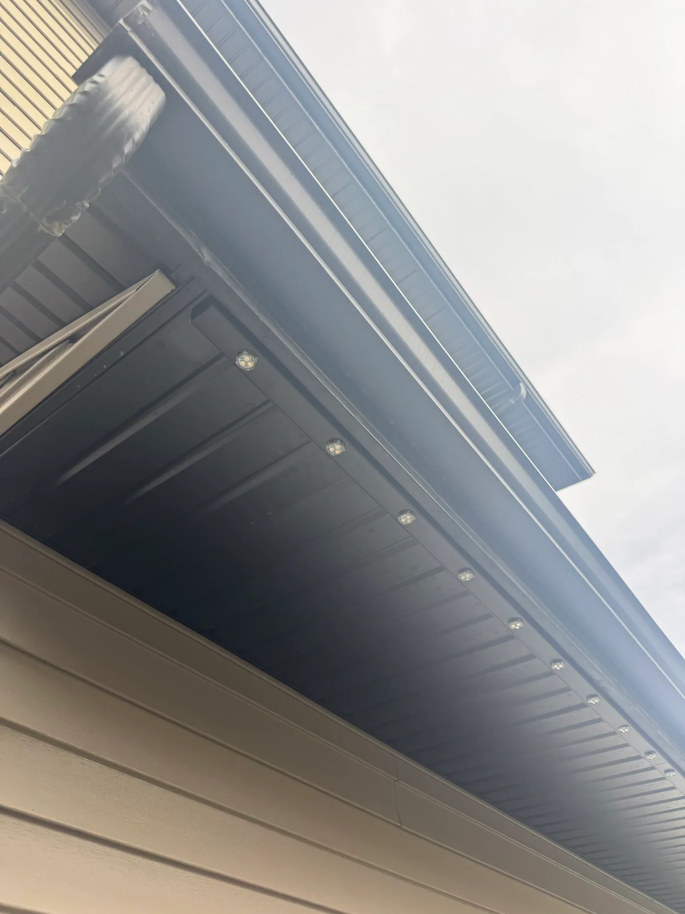 Prairie Lighting colour-matched aluminum track installed beneath a dark commercial-style soffit