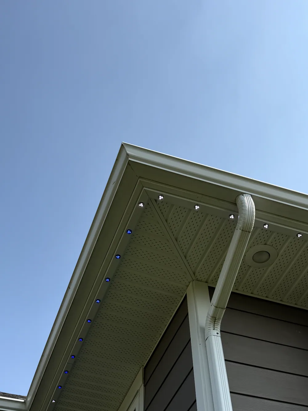 Prairie Lighting colour-matched aluminum track with illuminated 30mm Pro 24V RBGWW LED bulbs installed beneath an Edmonton home soffit